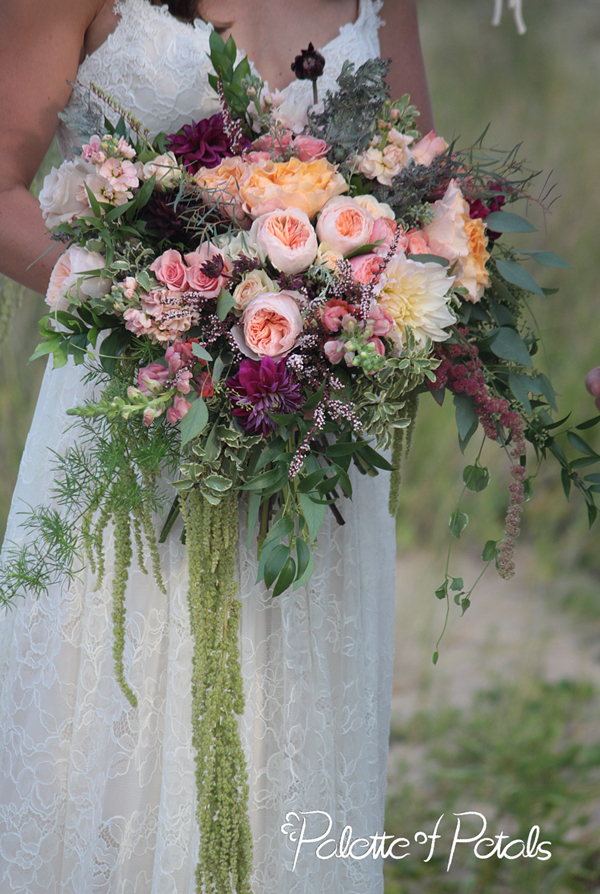 Lovely little flower girl with wreath of white baby roses, miniature carnations, rosemary, and delphinum